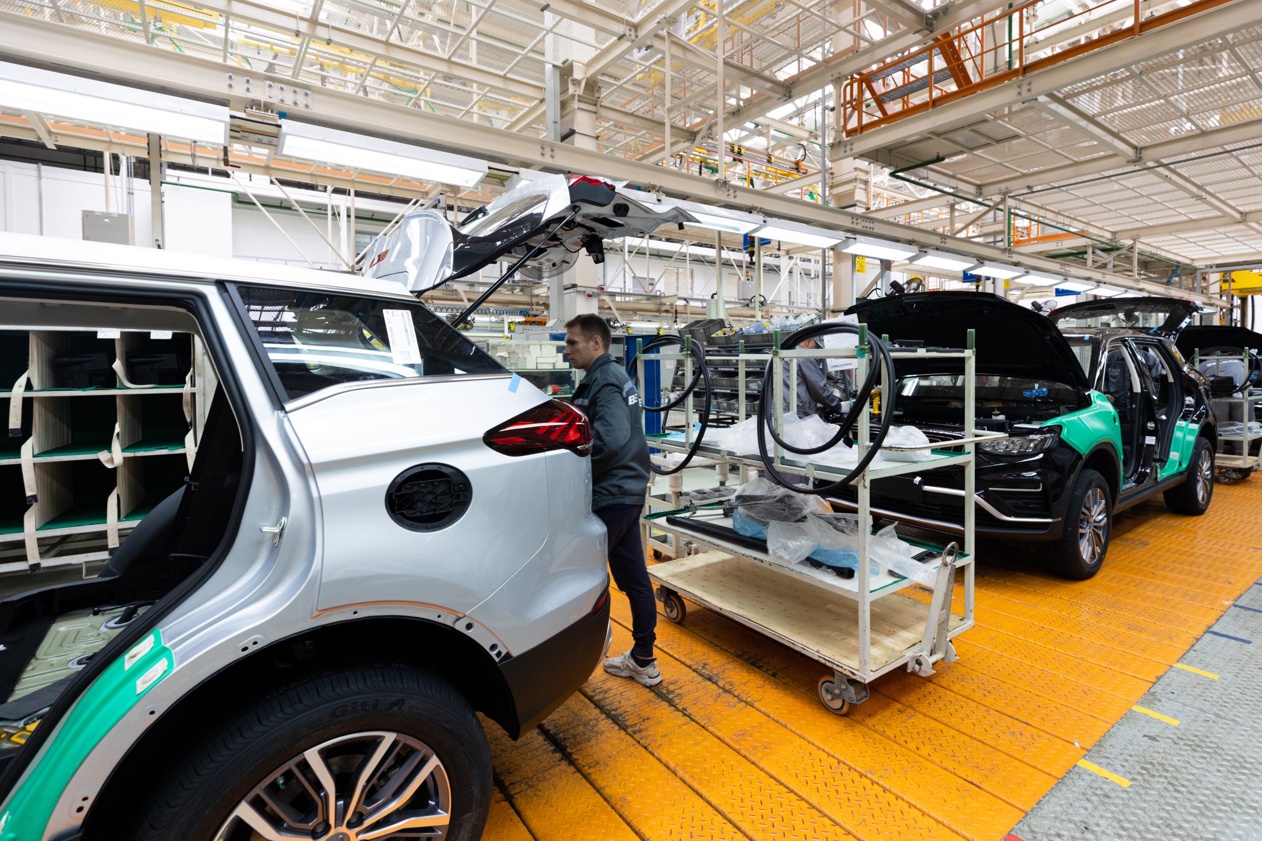 Car bodies are on assembly line. Factory for production of cars. Modern automotive industry. Electric car factory, conveyor.