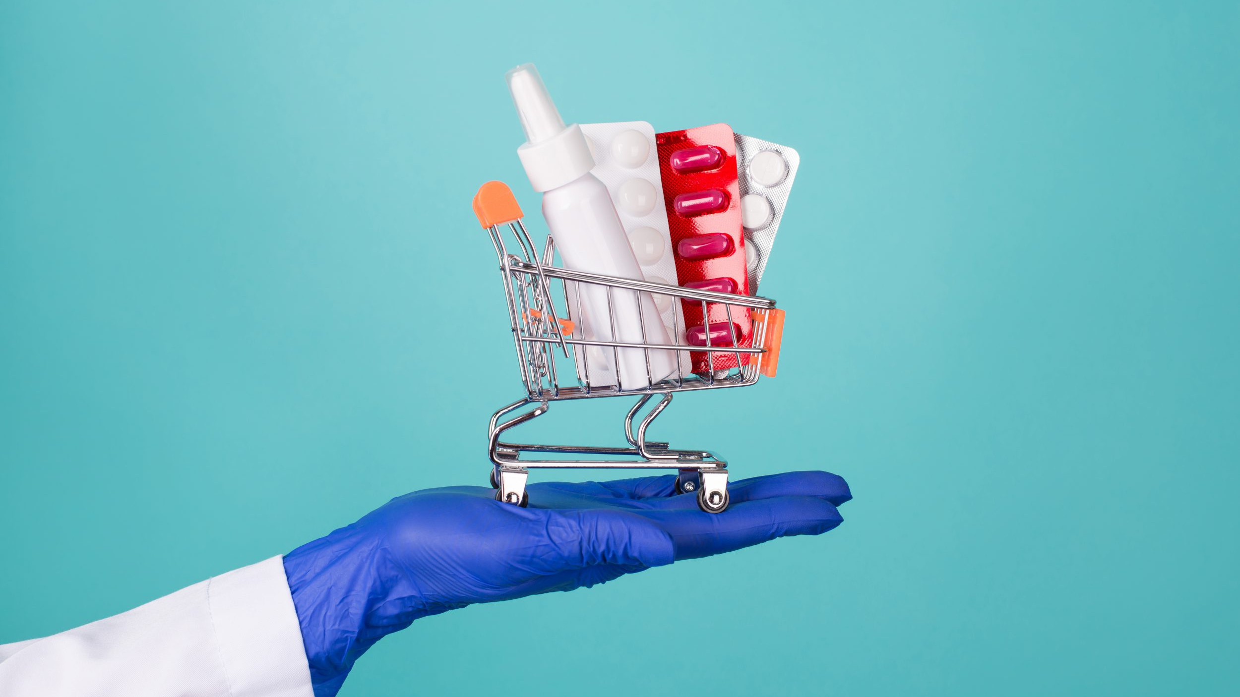 Help for patient concept. Close-up cropped photo of doc on hand in rubber latex gloves holding small cart with medicine blister