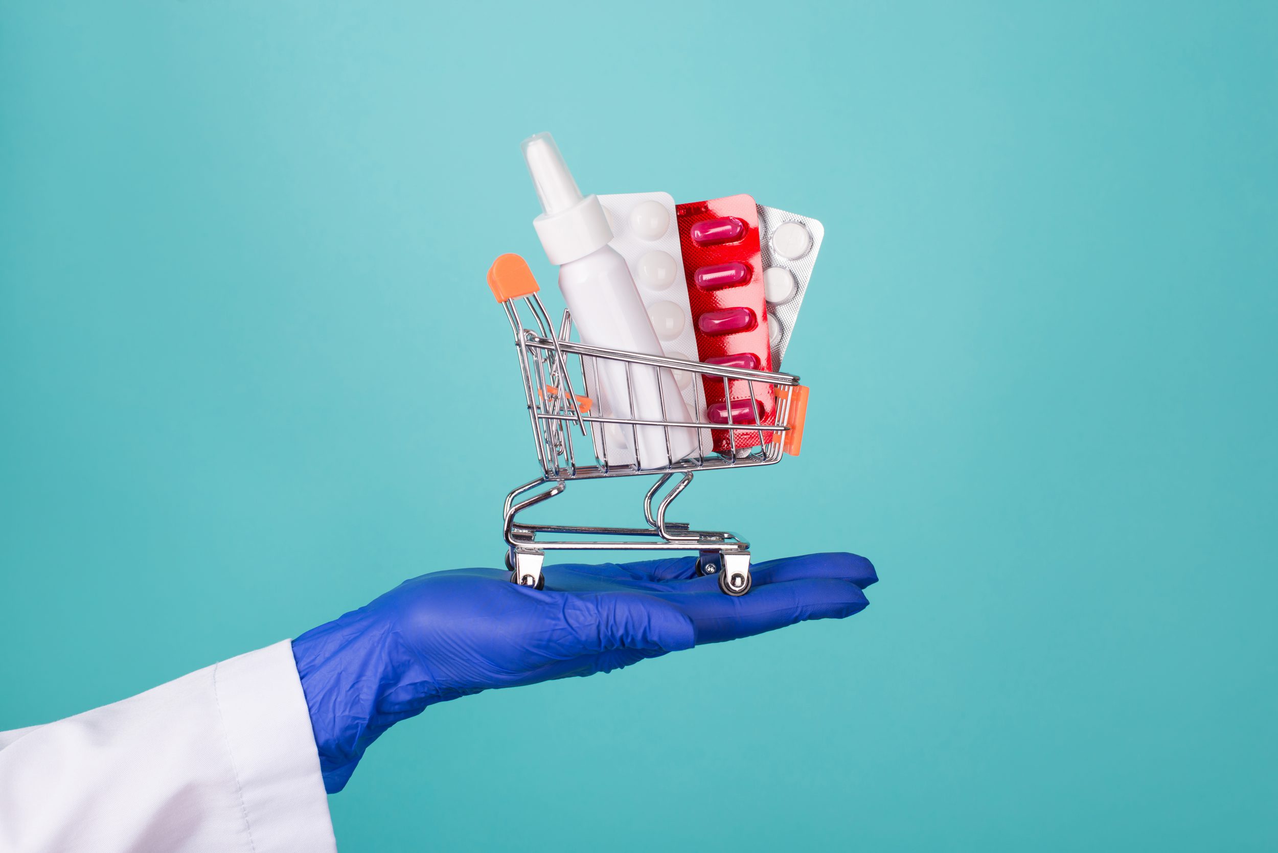 Help for patient concept. Close-up cropped photo of doc on hand in rubber latex gloves holding small cart with medicine blister