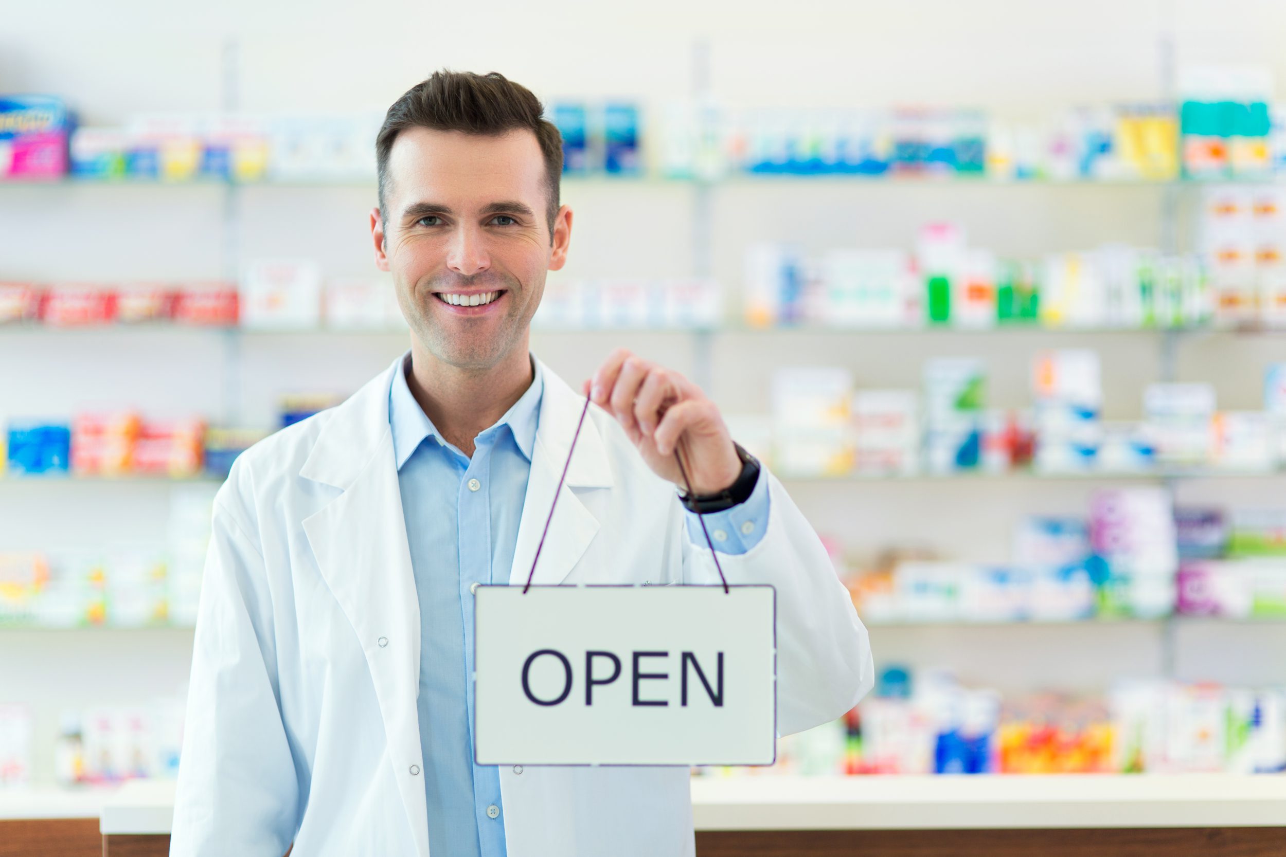 Pharmacist Holding An Open Sign