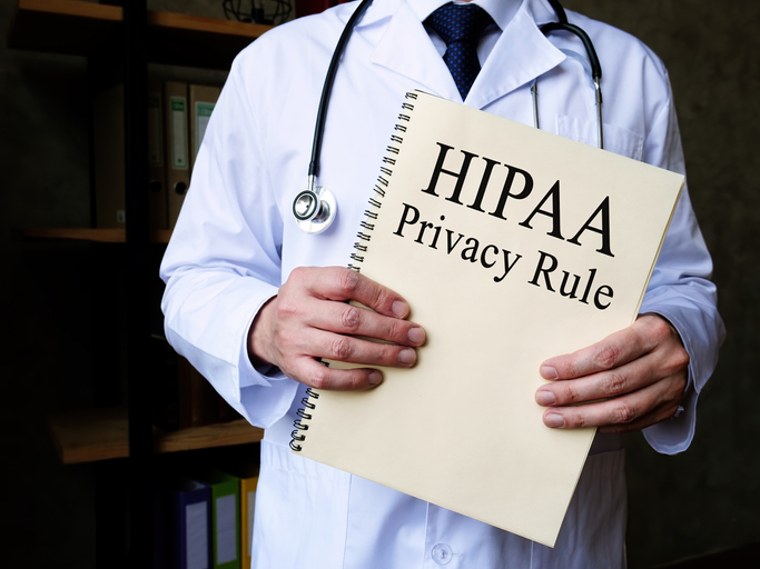 The doctor shows HIPAA privacy rule with Latest HIPAA Updates in his office.