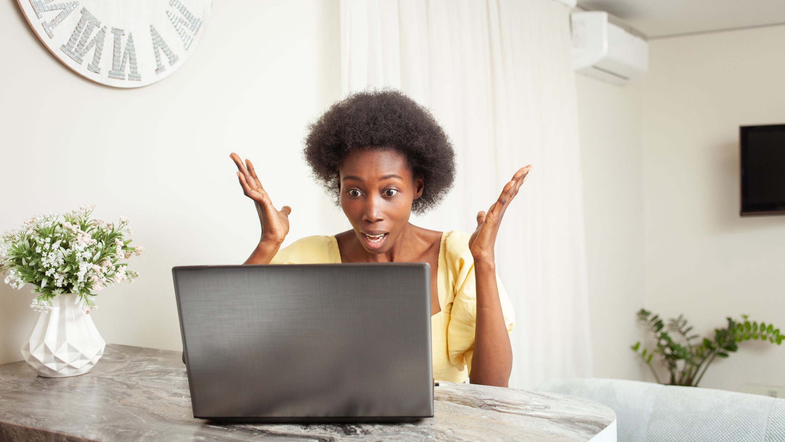 an African American Black Woman is surprised, stunned, angry at failure rate of her laptop