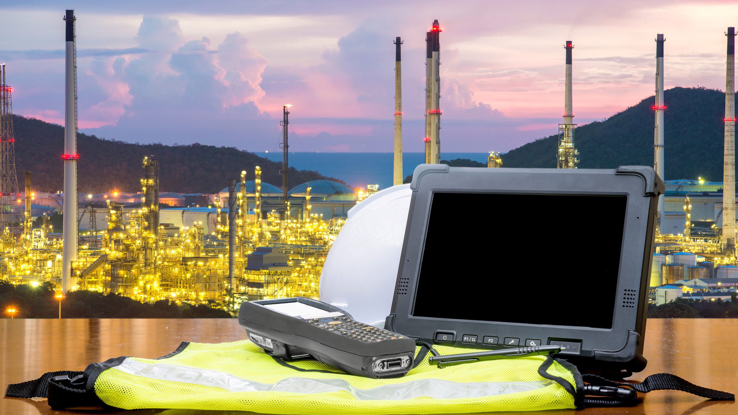 Rugged computers tablet in front of oil refinery industry.