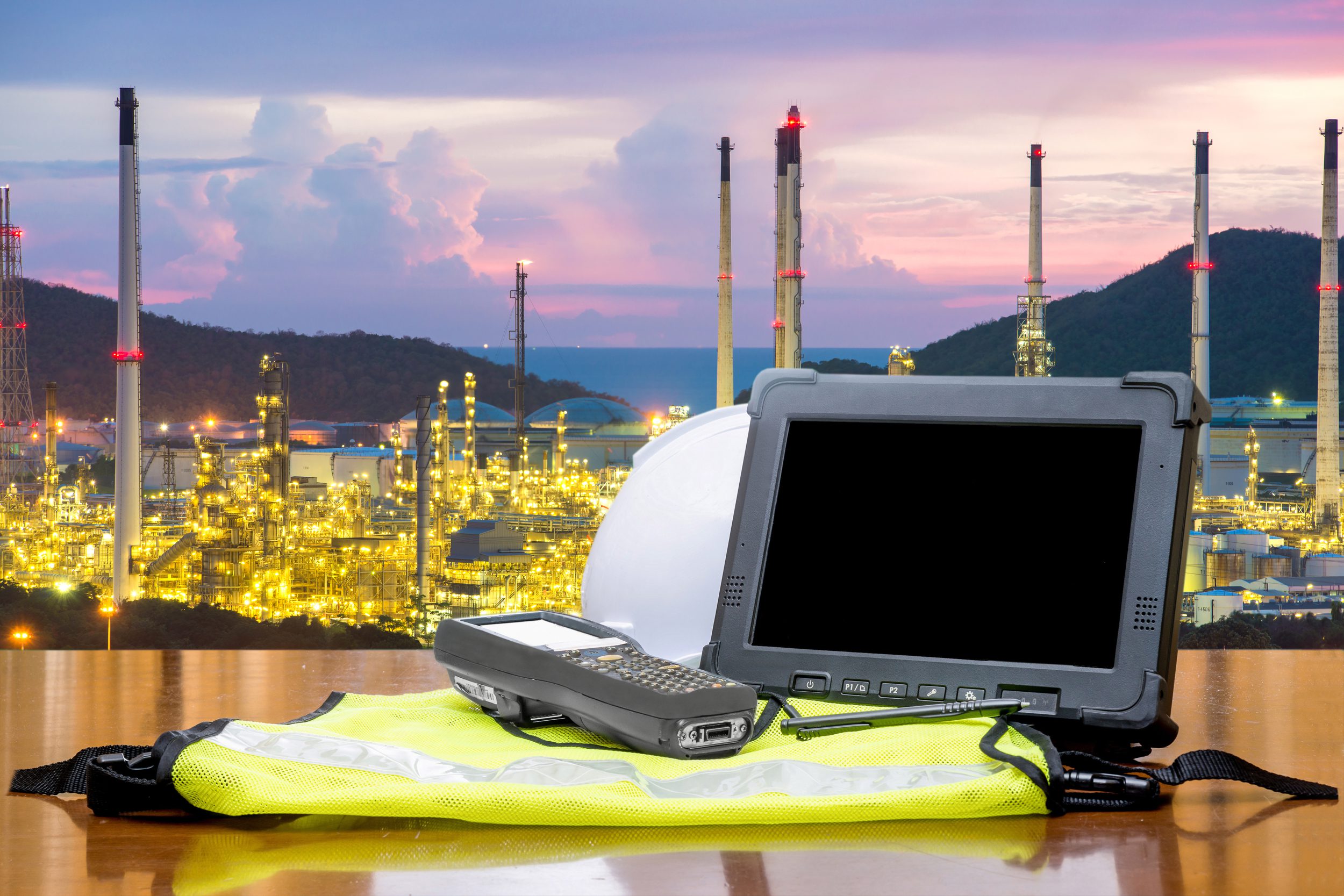 Rugged computers tablet in front of oil refinery industry.